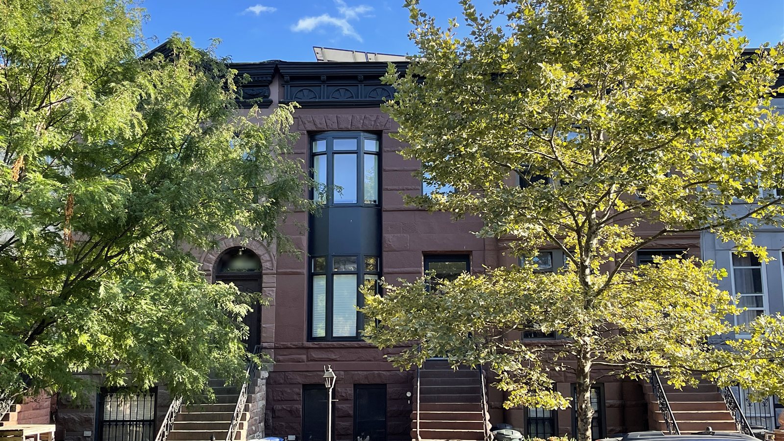 Brownstone with a new dark two-story bay window