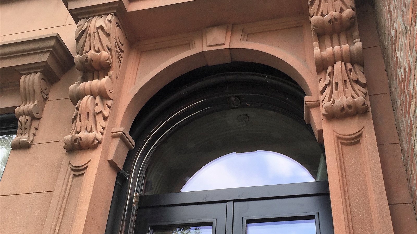 Brownstone entry with carved brackets and a new high-performance door