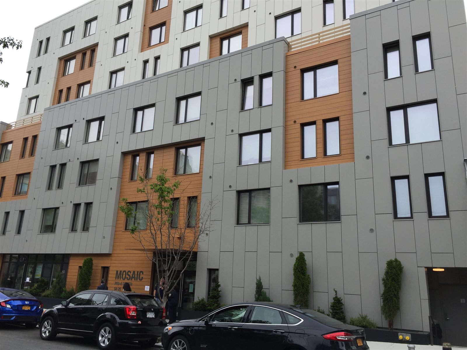 Eight-story apartment building with grey and wood-tone panels above a ground-floor pre-K